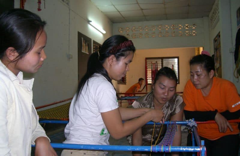 Thai woman teaching other women how to weave hammocks