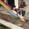 Girl sitting in colourful hammock in garden