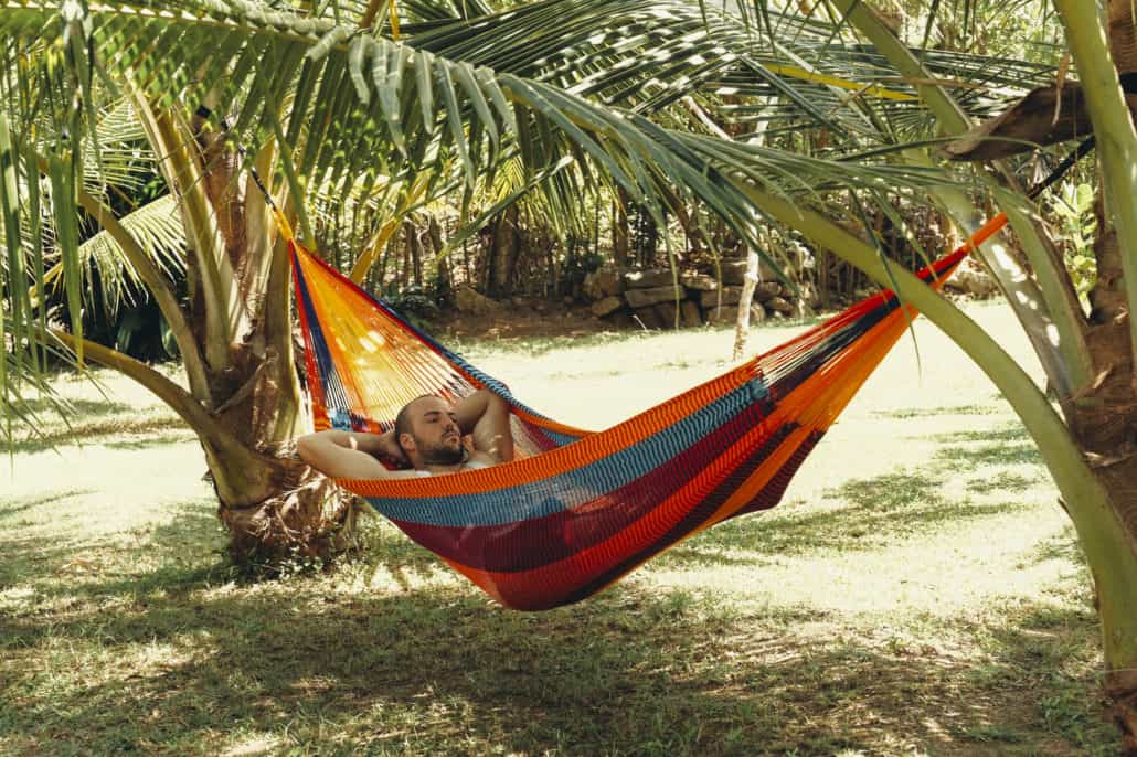 Surfer chilling in double hammock between two trees