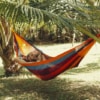 Surfer chilling in double hammock between two trees